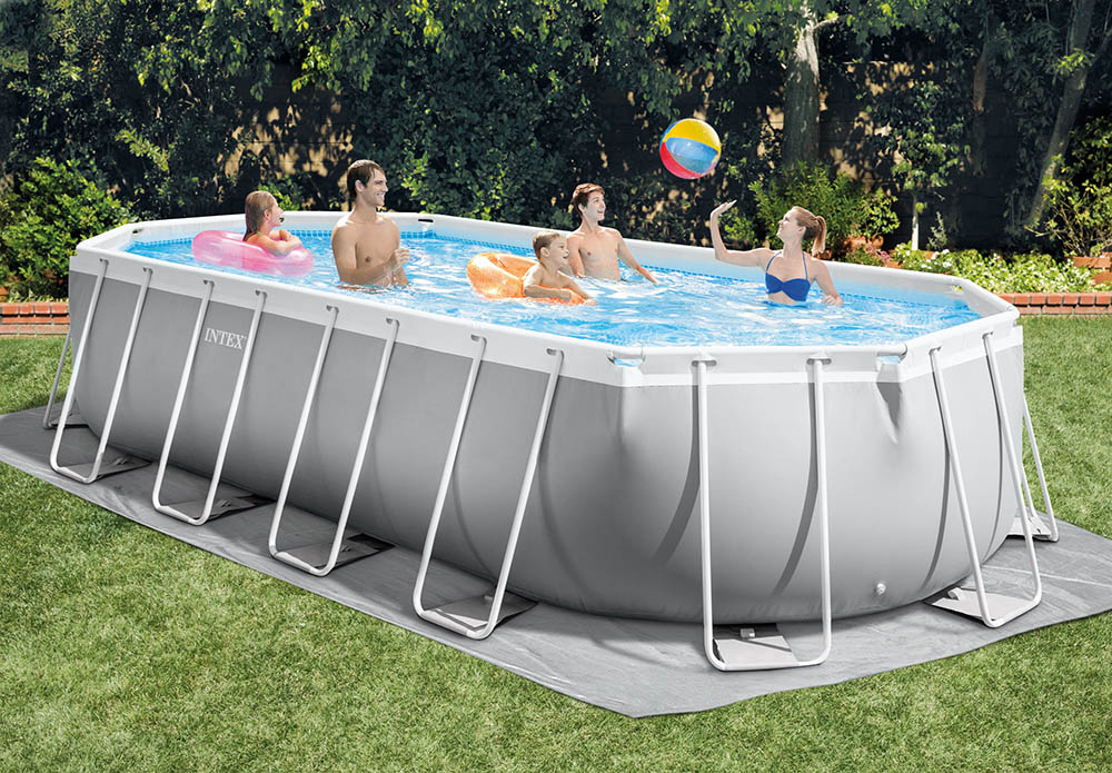 Плувен басейн Intex на открито с хора, които се наслаждават на водата и играят с топка. Лятна развлекателна дейност в задния двор, обградена от зеленина.